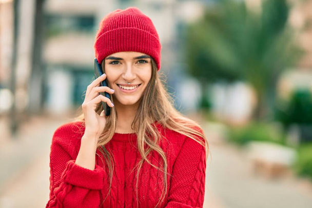 Jeune femme hispanique portant le style d'hiver parler sur le smartphone à la ville. - Photo, image