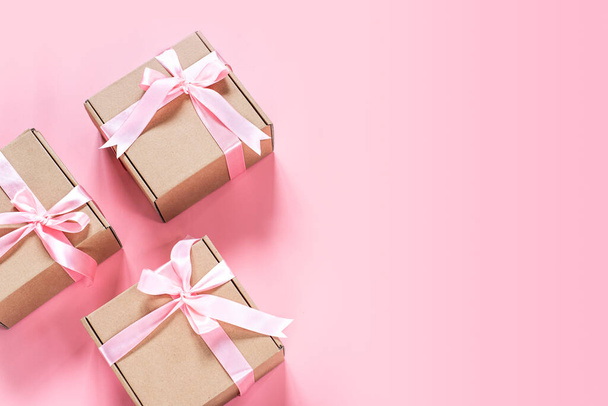 Geschenkdoos met roze lint strik op roze achtergrond - Foto, afbeelding