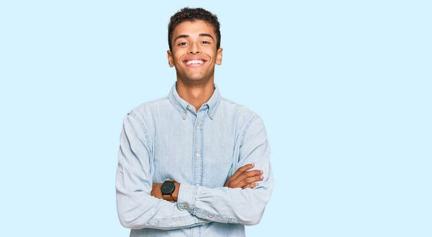 Young handsome african american man wearing casual clothes happy face smiling with crossed arms looking at the camera. positive person.  - Photo, Image
