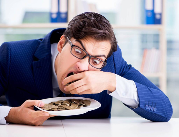 Homme d'affaires drôle manger des pièces d'or au bureau - Photo, image