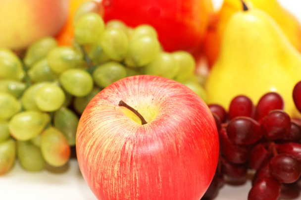 Punainen omena ja muut hedelmät taustalla
 - Valokuva, kuva