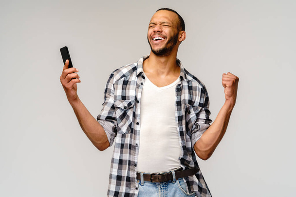 Portrait of a young african american man holding mobile cell phone - Foto, Bild