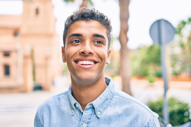 Fiatal latin férfi mosolyog boldog séta a városban. - Fotó, kép