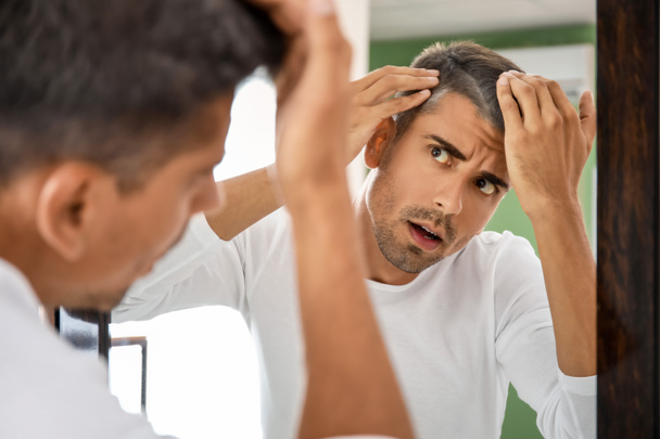 Homem estressado com cabelos grisalhos olhando no espelho - Foto, Imagem