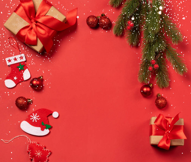 Festive boîtes de cadeaux avec des arcs rouges jouets de Noël sur un fond de confettis rouges - Photo, image