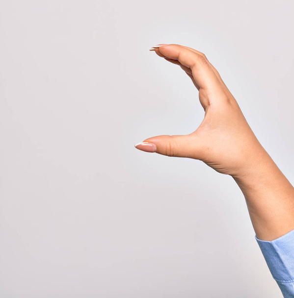 Hand der kaukasischen jungen Frau macht Fangzeichen über isoliertem weißem Hintergrund - Foto, Bild