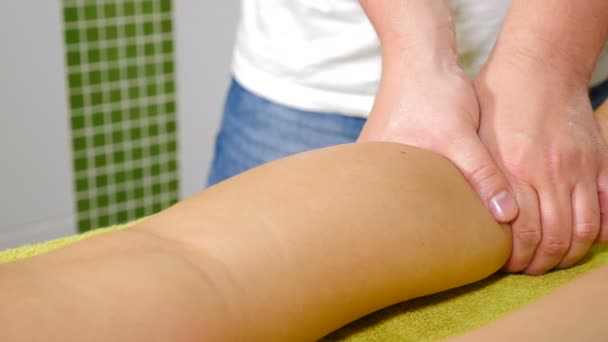 Бічний погляд на чоловічі руки робить масаж суворості. Розкішна служба масажу. Жіночий клієнт має професійний терапевтичний масаж лімфатичних дренажних ніг. Охорона здоров'я та благополуччя. 4 k відео - Кадри, відео