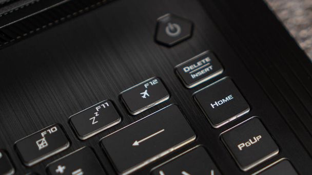 Przycisk trybu lotu, klawisz F12, przycisk samolotu na klawiaturze. Laptop płaski profil podświetlany klawiatura samolot tryb lotu zbliżenie - Zdjęcie, obraz