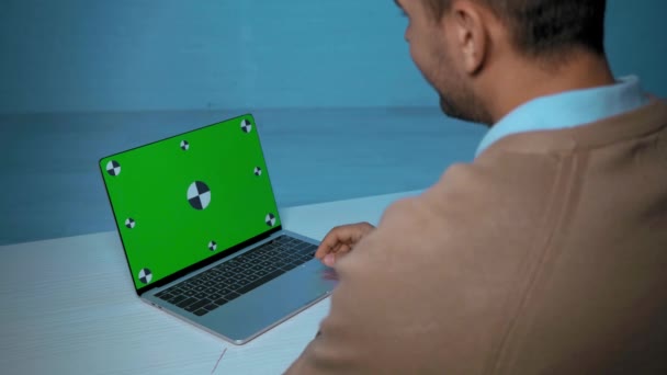vista cortada do homem acenando perto do laptop durante a chamada skype na mesa - Filmagem, Vídeo