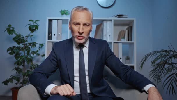 zelfverzekerde executive praten en gebaren tijdens skype call in office - Video