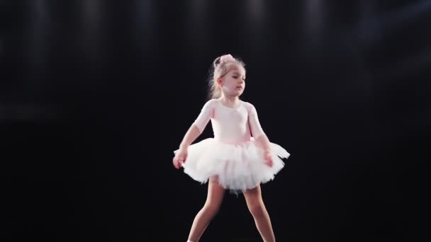 Petite fille ballerine apparence caucasienne dans un tutu rose danse sur scène. Les enfants. Mouvement lent. - Séquence, vidéo