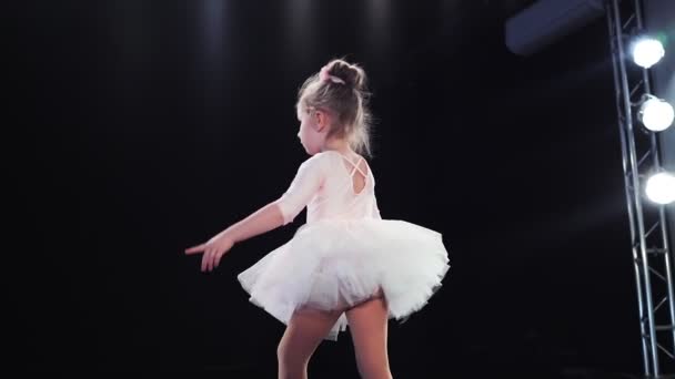 Menina bailarina aparência caucasiana em um tutu rosa dança no palco. Filhos. Movimento lento. - Filmagem, Vídeo