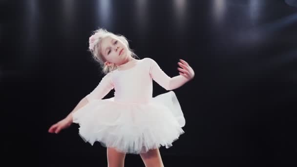 ピンク色のチュチュの女の子のバレリーナ白人の外観は、ステージ上で踊ります。子供たち。スローモーション.  - 映像、動画