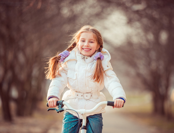 little girl on a bicycle - Фото, изображение