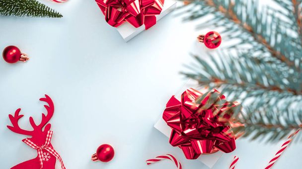 Karácsonyi vásár. Fehér ajándék skarlát íj, piros golyók és téli fa, cukorka karácsonyi dekoráció fehér háttér üdvözlő kártya. Karácsony, tél, újév koncepció - Fotó, kép