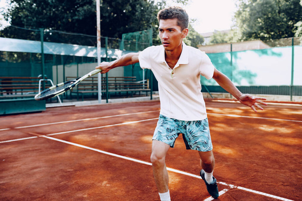 Fit man plays tennis on tennis field - Zdjęcie, obraz