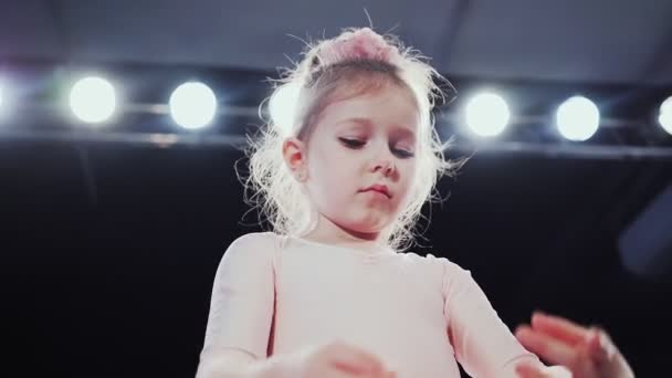 Menina bailarina aparência caucasiana em um tutu rosa dança no palco. Filhos. Movimento lento.  - Filmagem, Vídeo