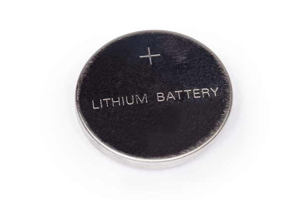 白色の背景にタイプと極性の指定を持つリチウムボタン電池、正端子側のクローズアップからの眺め - 写真・画像