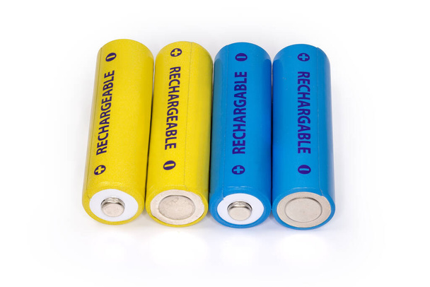 白の背景に黄色と青の充電式バッテリーAAサイズクローズアップ、トップビュー - 写真・画像