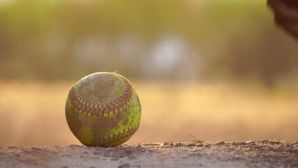 material de primer plano del bate de béisbol americano y la pelota en el suelo en la luz cálida, la mano del jugador levantando el bate de béisbol y corriendo  - Metraje, vídeo