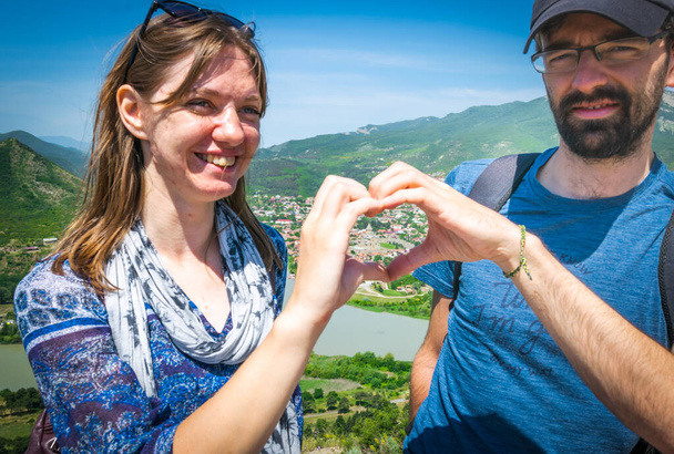 Close up kavkazský pár tvoří gesto ruku srdce pro cestování fotografie na dovolenou. - Fotografie, Obrázek
