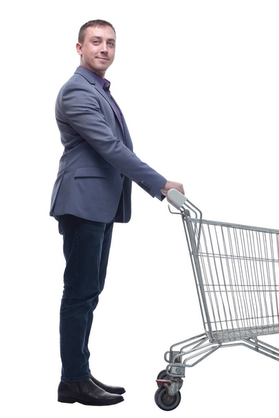 Full length view of handsome young man standing with shopping trolley and looking at camera - Fotó, kép