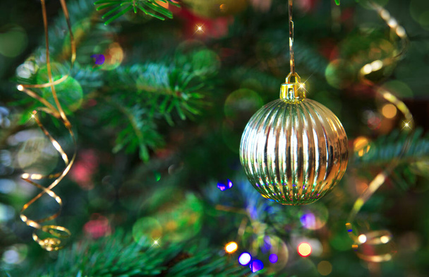 Karácsonyi bál lóg egy fenyőfa ágon. Karácsonyi háttér. - Fotó, kép