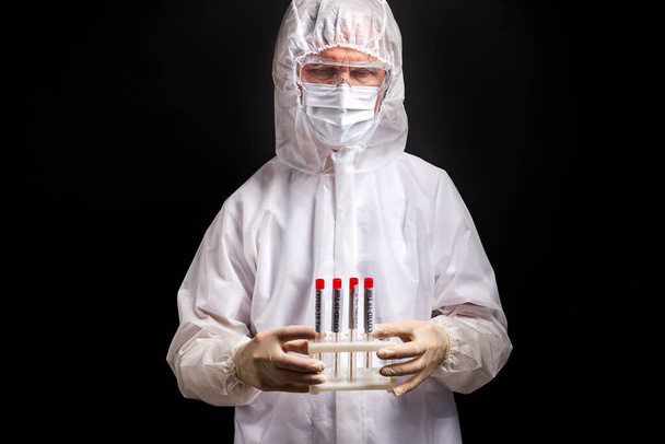 portrait of male doctor holding covid test tubes in hands - Fotoğraf, Görsel