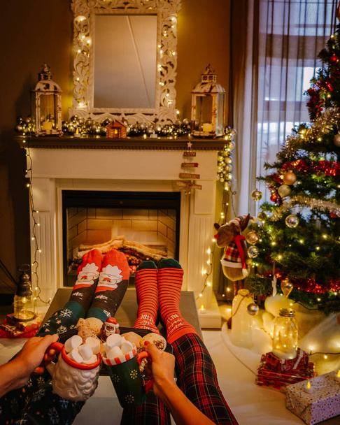 Christmas tree and fireplace, Christmas socks and hot chocolate cups by fireplace during Christmas - Photo, image