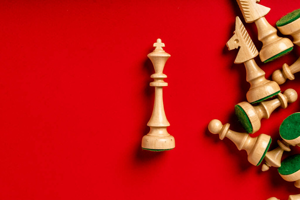 Pieza de ajedrez sobre fondo rojo con una pieza King separada resaltada, concepto de gestión y estrategia - Foto, imagen