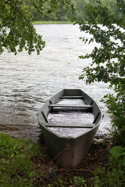 Dřevěný veslařský člun na břehu jezera. Klidná scéna na jezeře Baluosas v etnografické vesnici Suminai, Litva - Fotografie, Obrázek