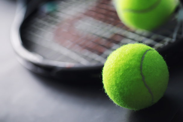 スポーツと健康的なライフスタイル。テニスだ。卓球用の黄色のボールとテーブルの上のラケット。テニスの概念を持つスポーツの背景. - 写真・画像