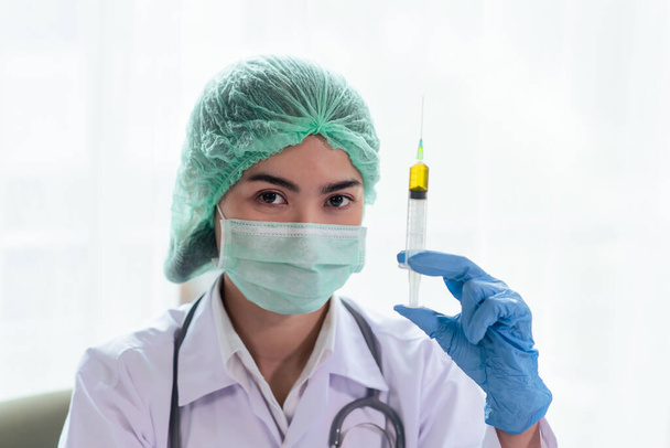 Primo piano di medico o scienziato donna con uno stetoscopio su siringa, scienza e chimica, assistenza sanitaria e concetto medico - Foto, immagini