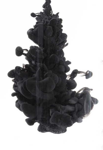 A vertical shot of black ink in the water - Фото, зображення