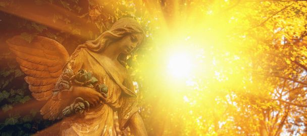 Estatua de ángel guardián a la luz del sol. Imagen horizontal. - Foto, imagen