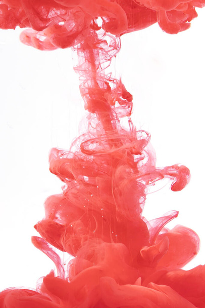 A vertical shot of red ink in the water - Valokuva, kuva
