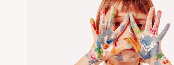Close up happy beautiful young child girl with children's face makeup and painting colorful hands. Free copy space for design or text. - Fotó, kép