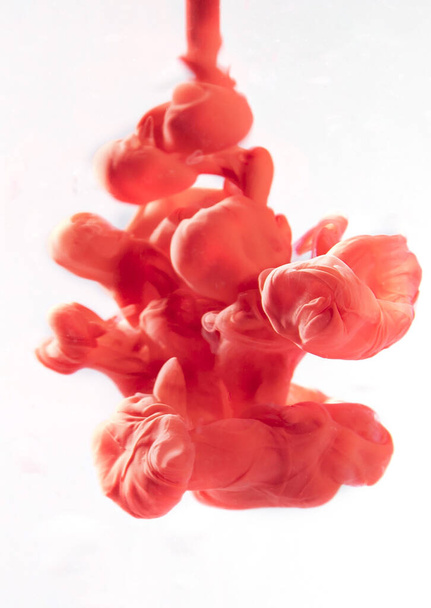 A vertical shot of red ink in the water - Photo, Image