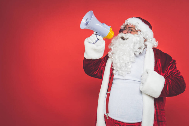 Funny crazy santa claus having fun on a red colored background - Photo, image