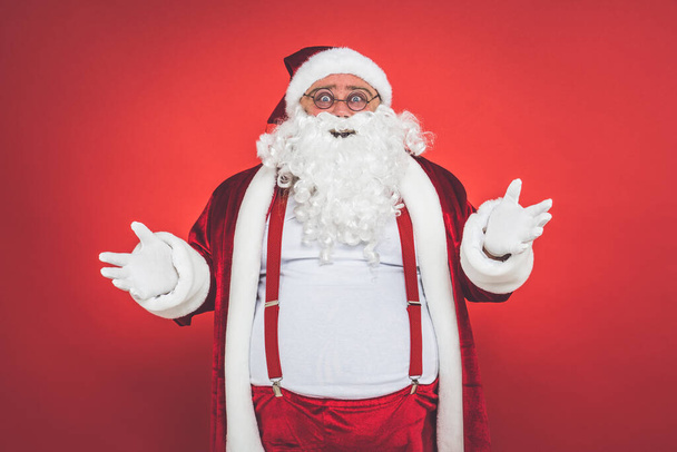 Funny crazy santa claus having fun on a red colored background - Photo, image