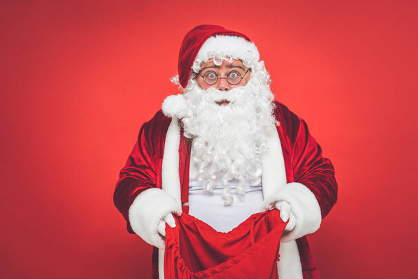 Funny crazy santa claus having fun on a red colored background - Foto, imagen