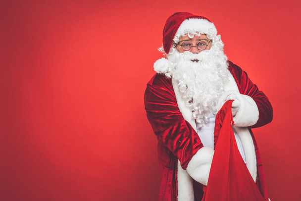 Funny crazy santa claus with tattoo having fun on a red colored background - Foto, Imagen
