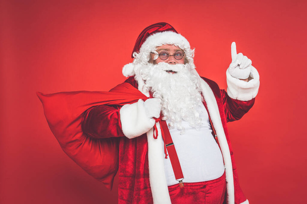 Funny crazy santa claus having fun on a red colored background - Fotografie, Obrázek