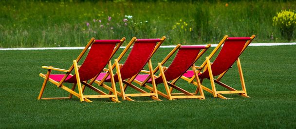 Cadeiras vermelhas no gramado
 - Foto, Imagem