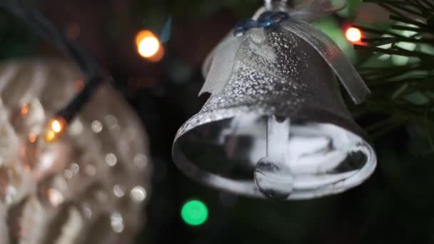 se centran en el timbre de juguete que suena en el árbol de Navidad con luces de guirnalda en el fondo - Metraje, vídeo