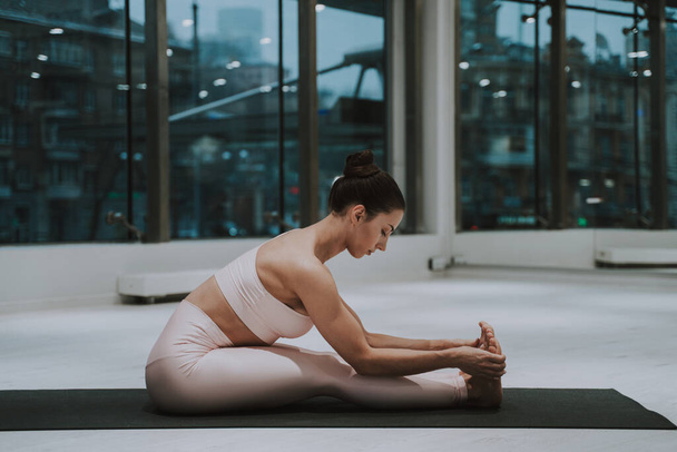 Beautiful girl training in the gym. Russian classic dancer doing stretching and yoga poses - 写真・画像