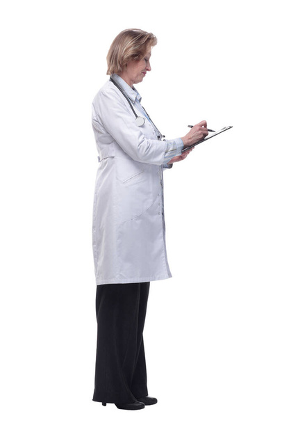 Side view of female doctor holding a clipboard and writing in it - Fotó, kép