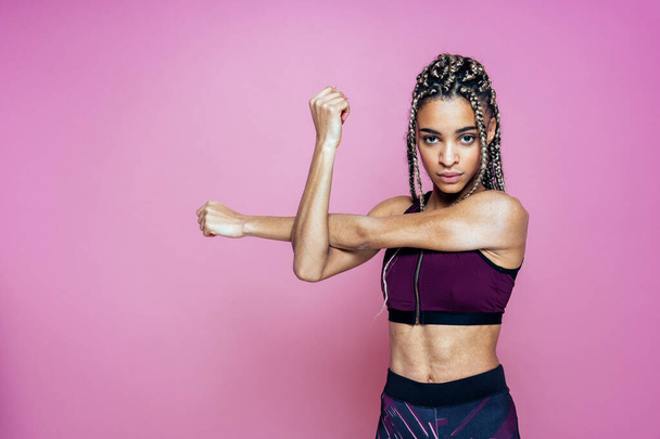 Beautiful girl doing exercises and sport. Posing on a pink colored background - Foto, Imagem