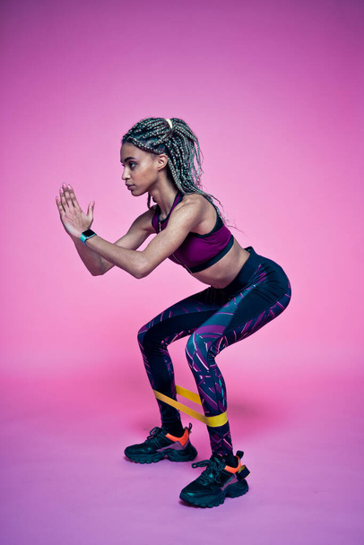 Beautiful girl doing exercises and sport. Posing on a pink colored background - Foto, Imagem