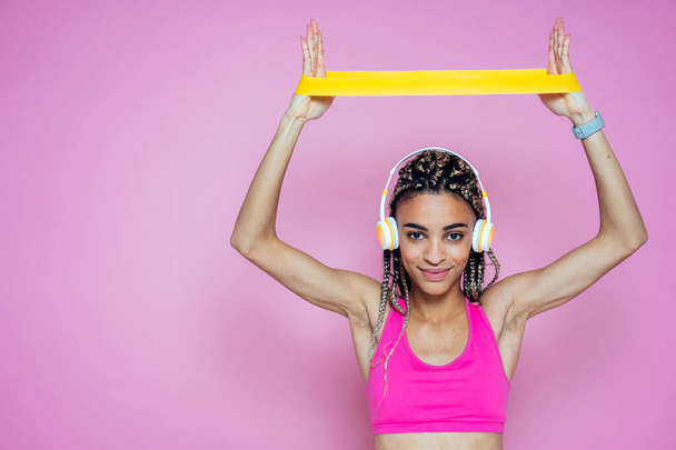 Beautiful girl doing exercises and sport. Posing on a pink colored background - Zdjęcie, obraz